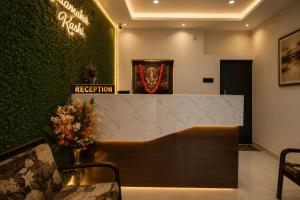 a lobby with a reception desk and a green wall at Hotel Vibe Blu Near JHV Mall in Varanasi