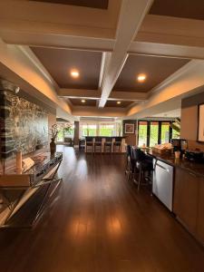 a large room with a kitchen and a bar with chairs at White Rock Joy Inn in White Rock
