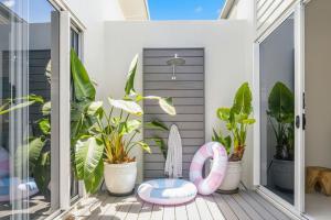 a porch with plants and a pink and white ottoman at Rock Salt Villa 2 in Picnic Bay