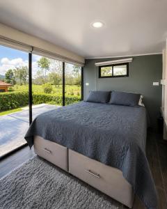 a bedroom with a bed and a large window at Villa Los Perezosos - Private Jacuzzi & Arenal Volcano View - La Fortuna in Fortuna +44 photos