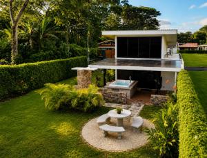 a backyard with a fireplace and a house at Villa Los Perezosos - Private Jacuzzi & Arenal Volcano View - La Fortuna in Fortuna