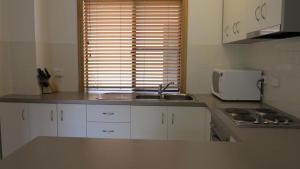 a kitchen with white cabinets and a sink and a window at Sol Y Olas Sun and Waves in Arcadia +9 photos