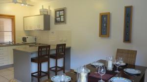 a kitchen with a table and chairs with wine glasses at Sol Y Olas Sun and Waves in Arcadia