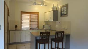 a kitchen with a counter and two chairs in it at Sol Y Olas Sun and Waves in Arcadia