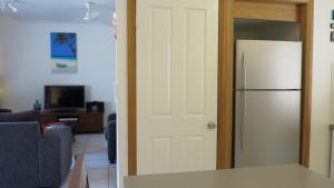 a kitchen with a refrigerator and a living room at Sol Y Olas Sun and Waves in Arcadia