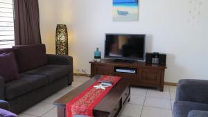 a living room with a couch and a tv at Sol Y Olas Sun and Waves in Arcadia