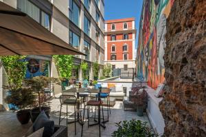 a patio with tables and chairs in a building at The Spring House Hotel Rome Vatican, Tapestry Collection Hilton in Rome