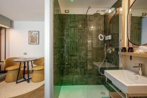 a bathroom with a glass shower and a sink at The Spring House Hotel Rome Vatican, Tapestry Collection Hilton in Rome +133 photos