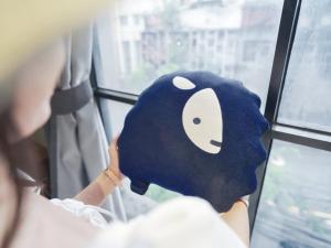 a woman is looking out of a window with a mask at Kokotel Bangkok Surawong in Bangkok