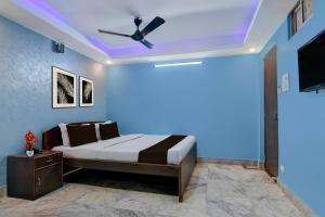 a bedroom with a bed and a ceiling fan at Hotel O Calcutta University Formerly Hamza International in Kolkata