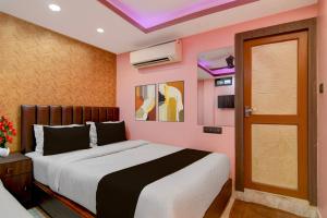 a bedroom with a large bed and a pink wall at Hotel O Calcutta University Formerly Hamza International in Kolkata