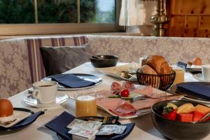 a table with a breakfast of bread and fruit on it at Hotel Zum Stern inkl Gasteiner Bergbahnen im Sommer in Bad Hofgastein