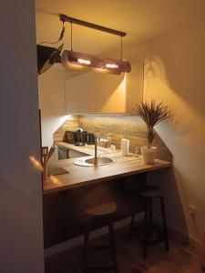 a kitchen with a counter with a sink and a light at Słoneczny Zakątek a in Złotów