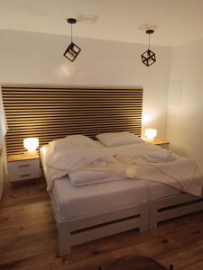 a bedroom with a large bed with two lights on it at Słoneczny Zakątek a in Złotów