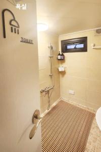 a bathroom with a shower with a tiled floor at Young Stay in Seoul +60 photos