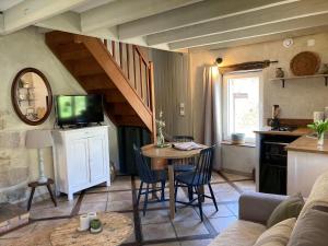 a living room with a table and a kitchen at La maison d'André in Laurière