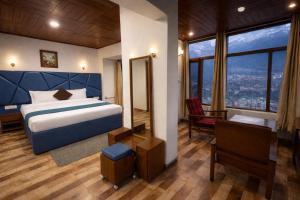 a bedroom with a bed and a large window at The Himalayan Nomad Manali - 2 bedrooms mountain view independent villas with personal lawn in Manāli