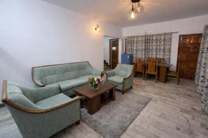 a living room with two couches and a table at The Himalayan Nomad Manali - 2 bedrooms mountain view independent villas with personal lawn in Manāli