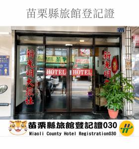 a sign for a hotel with glass doors at New Bright Hotel in Zhunan