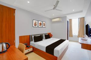 a hotel room with a bed and a desk and a table at Townhouse Oak Ujjain Railway Station Formerly Kasliwal Inn in Ujjain +24 photos