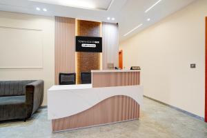 a lobby with a reception desk and a couch at Townhouse Oak Ujjain Railway Station Formerly Kasliwal Inn in Ujjain