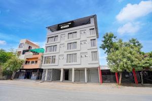 a tall white building on the side of a street at Townhouse Oak Ujjain Railway Station Formerly Kasliwal Inn in Ujjain