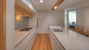 a kitchen with a sink and a stove top oven at Maggies Beachfront Apartment 11 in Horseshoe Bay +18 photos