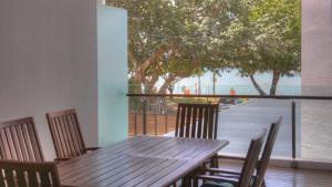 a wooden table and chairs with a view of the beach at Maggies Beachfront Apartment 11 in Horseshoe Bay