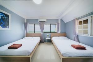 two beds in a room with blue walls and windows at Gao Bee One Beach Club in Ban Phala