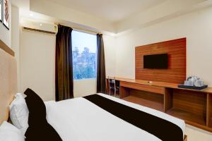a hotel room with a bed and a television at Super Collection O Friends Colony Lucknow Formerly The Suite in Lucknow
