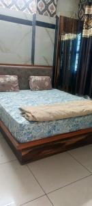 a wooden bed sitting on top of a room at Hotel Gaurav in Ahār +2 photos