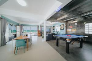a room with a ping pong table and a dining room at Gao Bee One Beach Club in Ban Phala