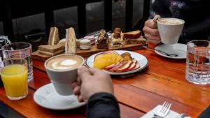 two people sitting at a table with coffee and food at Hotel Vibe Blu Near JHV Mall in Varanasi +16 photos