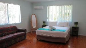 a bedroom with a bed and a couch at Lanas Cottage in Arcadia +10 photos