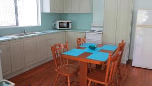 a kitchen with a table and chairs and a refrigerator at Lanas Cottage in Arcadia