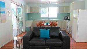 a living room with a couch and a kitchen with a table at Lanas Cottage in Arcadia