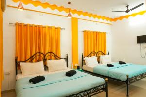 two beds in a room with orange curtains at Hostel Mama in Udaipur +33 photos