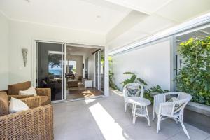 a patio with wicker chairs and tables on a house at Reflections Amber Villa 2 in Picnic Bay +11 photos