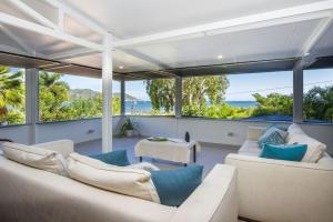 a living room with couches and a view of the ocean at On the Beach in Horseshoe Bay