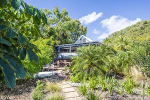 a house on a hill with palm trees at On the Beach in Horseshoe Bay