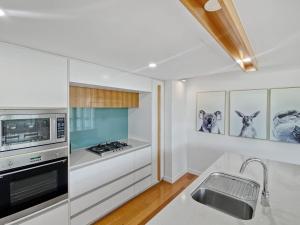 a kitchen with a sink and a stove top oven at Maggies Beachfront Apartment 12 in Horseshoe Bay