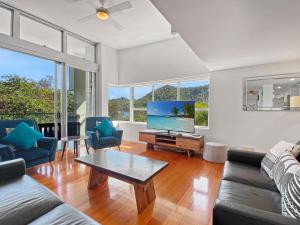 a living room with a couch and a tv at Maggies Beachfront Apartment 12 in Horseshoe Bay
