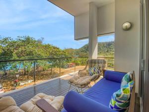 a living room with a blue couch and a balcony at Maggies Beachfront Apartment 12 in Horseshoe Bay