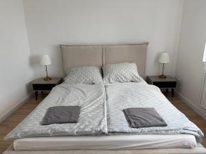 a large white bed with two nightstands and two lamps at Apartamenty u Rybaka in Stężyca