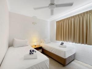 a room with two beds and a window at Arcadia Palms 1 in Arcadia