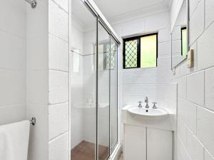a white bathroom with a sink and a shower at Arcadia Palms 1 in Arcadia