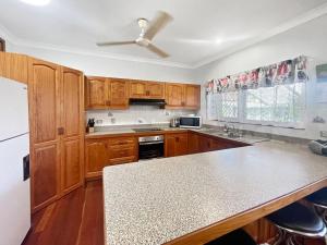 a kitchen with wooden cabinets and a ceiling fan at Arcadia Gardens in Arcadia