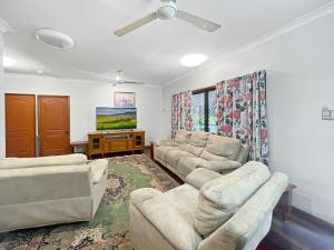 a living room with couches and a flat screen tv at Arcadia Gardens in Arcadia
