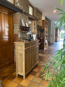 a kitchen with wooden cabinets and a tile floor at La Maison du Poelon in Labarthe-sur-Lèze