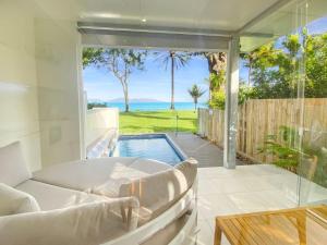 a living room with a tub and a view of the ocean at Rock Salt Villa 1 in Picnic Bay +3 photos